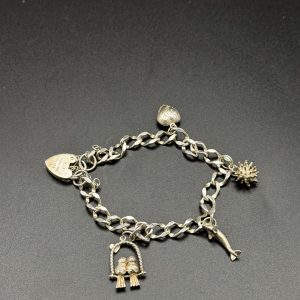 Sterling silver charm bracelet with four charms and heart locket